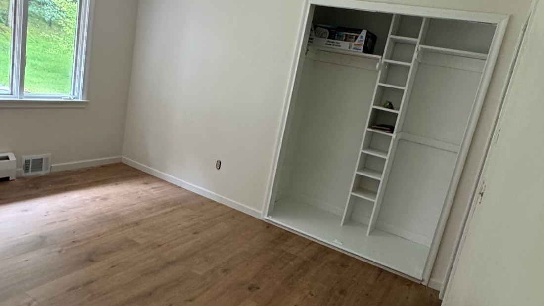 Empty room with newly installed laminate flooring and white walls